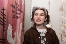 Student looks at pink canvas with writing on the wall