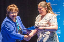 A woman is presented with her certificate by another woman