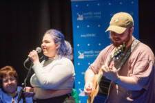 A male a female students on the stage singing