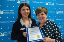 two women smiling they are standing in front of signs with NWRC on them