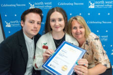Three people huddle close together with a certificate