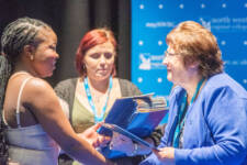A student presented with her certificate by another woman