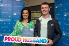 A man and woman with a proud husband sign