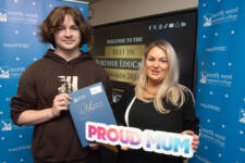 Man and woman with a proud mum sign