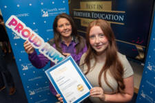 two women hold a certficate and a proud mum sign