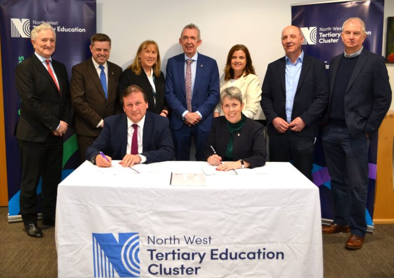 group of people around a table attending the signing of important documents
