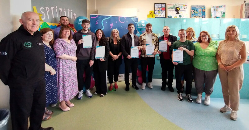 group of people standing wearing holding certificates