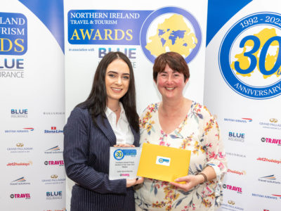 Female tourism student and her lecturer at awards ceremony holding the award