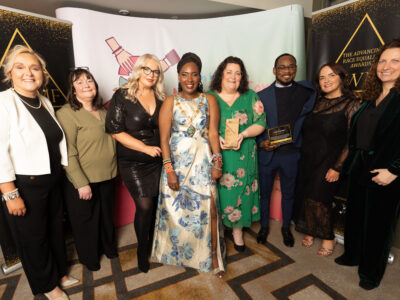 group of women and one man pictured with an award