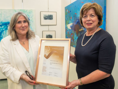 Two members of staff pictured holding the bronze award