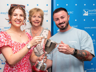 Three people pictured holding the award