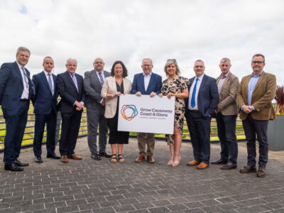 ten people pictured outside holding a graphic