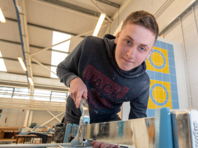 Student using tools in tiling workshop