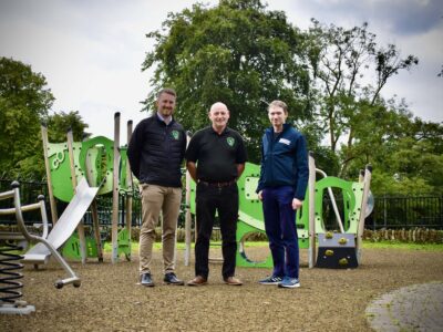 Three men standing in a children's playground