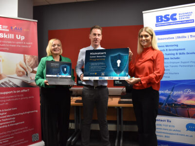 Three people holding signs for cyber security holding a laptop and ipad