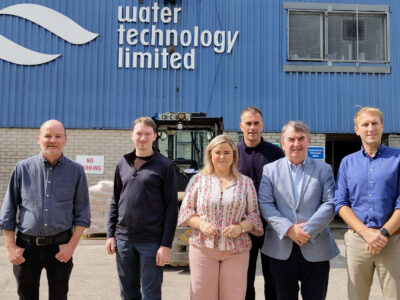 Six people standing outside a building with the branding Water Technology Ltd.