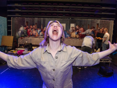 A student in the theatre in a screaming pose