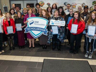 A large group of people smiling - they are holding props for NWRC and SSE renewables.