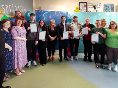 group of people standing wearing holding certificates