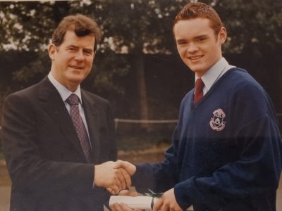 Man and schoolboy shake hands