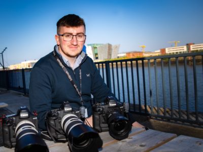 Man pictured on a quayside with cameras in front of him