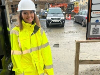 woman wearing high vis and hat on construction site